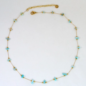 Detail of light blue natural stone beads on a golden stainless steel chain with lobster clasp