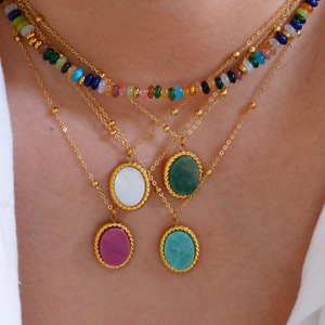 French vintage gold layered necklaces with colorful natural stone oval pendants on a model