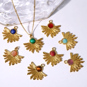 Détail de pendentifs bohèmes en forme d'éventail dorés avec diverses pierres naturelles