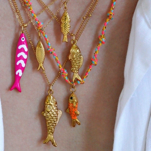 Detalle de collares de peces dorados en capas con cordones de colores y colgantes mar