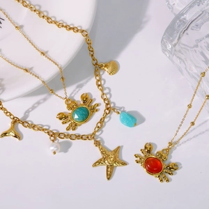 Gold stainless steel ocean jewelry set with crab, starfish, and shell charms