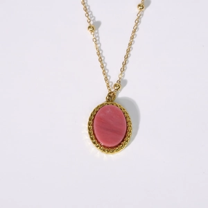 Detail of vintage gold necklace with pink oval natural stone and beaded chain detail
