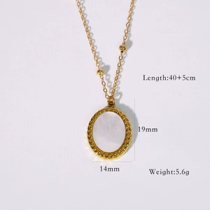 Macro detail of oval pendant necklace with twisted gold frame and white shell inlay