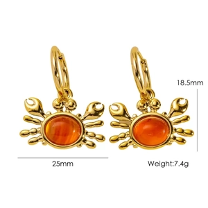 Detailed view of gold crab earrings with orange gemstones and 25mm measurement