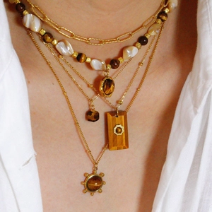 Detailaufnahme der mehrlagigen Tigerauge-Halsketten mit Barockperlen auf goldenem Edelstahl