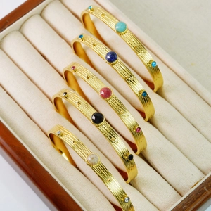 Detalle de cinco brazaletes dorados con diversas incrustaciones de piedras preciosas