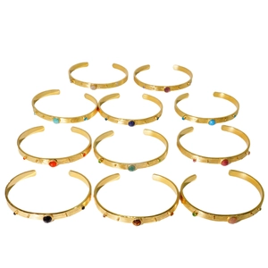 Set de brazaletes de acero dorado con piedras naturales coloridas sobre fondo blanco