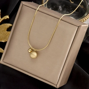 Elegant gold snake chain necklace with polished and frosted bead pendants in macro view