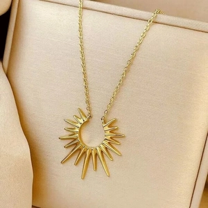Collier pendentif soleil doré au design irrégulier minimaliste sur boîte à bijoux