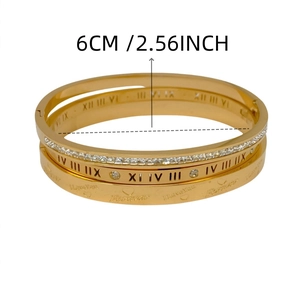 Detail van gouden titanium armbanden met Romeinse cijfers en hartgravures