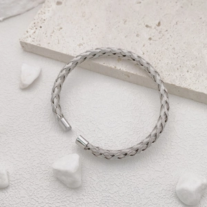 Detailed macro view of silver braided cable pattern on the titanium steel cuff bracelet