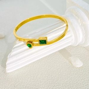 Elegante bracciale rigido in acciaio al titanio dorato con pietre verdi rettangolari e a goccia