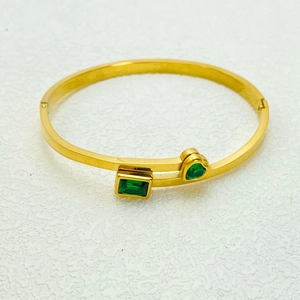 Dettaglio del bracciale placcato oro con pietre preziose verdi rettangolari e a forma di cuore