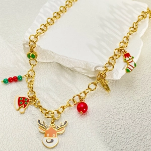 Detailweergave van de kerstbedeltjes met rendier en sokken aan een gouden ketting