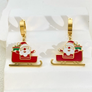 Detail van kerstoorbellen met de kerstman op een slee en rood en groen emaille coating