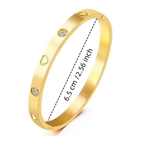 Detalle macro de la pulsera de corazón en acero dorado con diámetro interno de 6,5 cm