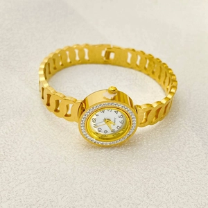 Close-up of gold stainless steel bangle watch with rhinestone bezel and hollow chain strap