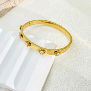 Detail view of 18K gold plated stainless steel bangle with pearl daisy motifs