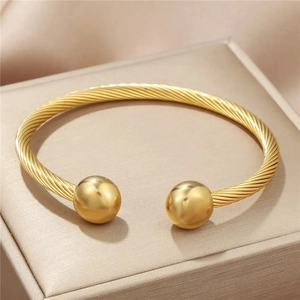 Gold-plated stainless steel twisted cable open bangle featuring polished ball ends