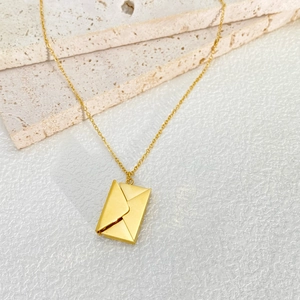 Close-up of 18k gold plated envelope pendant on a delicate stainless steel O-chain