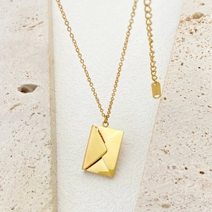 Polished 18k gold plated stainless steel envelope locket pendant on stone surface