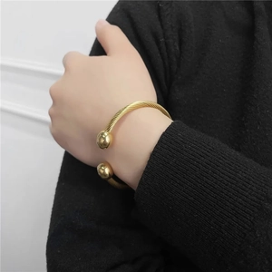 Minimalist gold titanium steel open cable bracelet featuring dual polished spherical ends