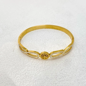 Detail of gold tree of life bangle with rhinestone pave and hollow teardrop design