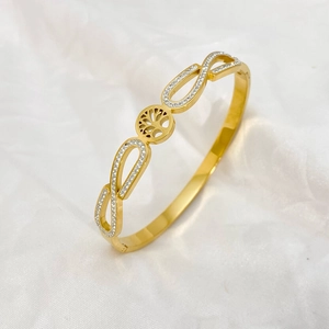 Detailed view of Tree of Life gold bracelet with crystal infinity symbols on satin