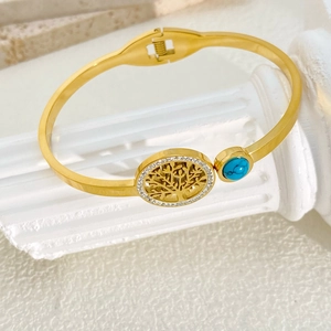 Close-up of gold Tree of Life bracelet with embedded crystals and turquoise stone