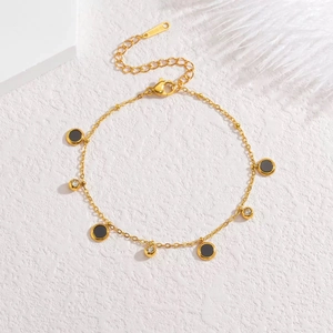 Close-up of gold stainless steel necklace with black round charms and zircon spheres