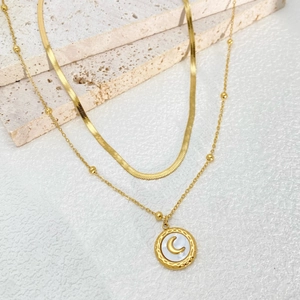 Double-layered gold snake chain necklace featuring a white shell moon pendant on stone
