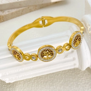 Macro detail of gold-plated tree of life bangle with sparkling white zircon crystals