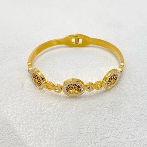 Close-up of golden Tree of Life bangle with white crystals and side-open clasp detail