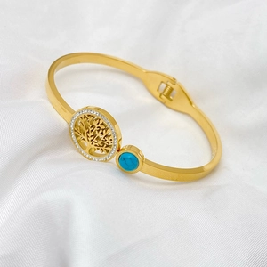 Detail of gold Tree of Life bracelet featuring sparkling white zircons and turquoise stone