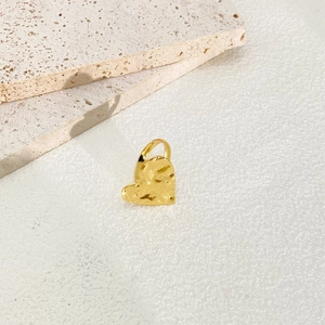 Detailed close-up of golden adjustable ring featuring a unique hammered heart shape design