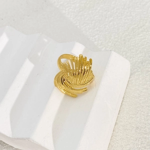 Detailed macro view of gold-plated adjustable ring with radiant wavy texture on pedestal