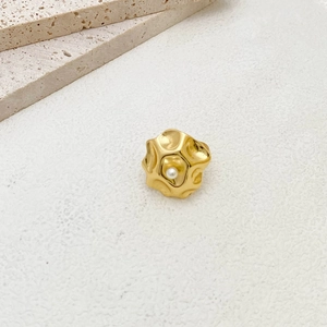 Macro shot of minimalist gold textured ring with a central white pearl detail