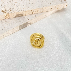 Detail of adjustable gold titanium ring with spiral design and granular texture