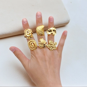 Detail view of adjustable gold-tone rings featuring floral heart and pearl accents