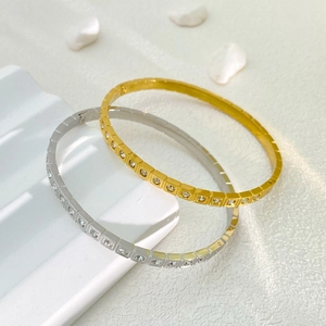 Dettaglio di bracciali in acciaio inossidabile oro e argento con cristalli lucidi