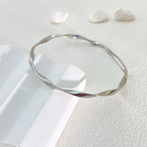 Polished silver Mobius bangle in twisted stainless steel design on minimalist stone