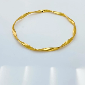 Macro view of gold Mobius twist bracelet with a high-polished mirror finish surface