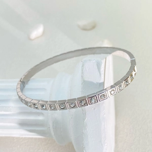 Dettaglio di un bracciale in acciaio al titanio argento con una fila di zirconi quadrati lucidi