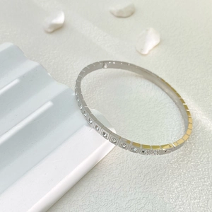 Dettaglio bracciale in acciaio argento con zirconi quadrati incastonati e chiusura a scatto