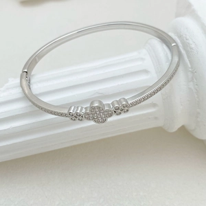 Minimalist silver clover bangle with sparkling zircon stones in an open-end design