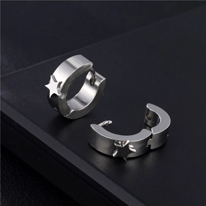 Boucles d'oreilles créoles en acier avec breloques étoiles sur un socle en cuir noir