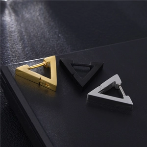 Vue macro de boucles d'oreilles triangulaires en or noir et acier inoxydable poli brillant