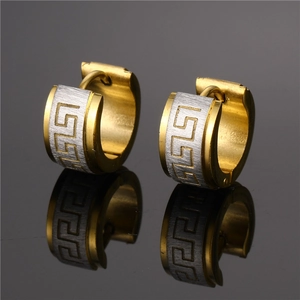Close-up of dual-tone stainless steel hoop earrings with Greek key pattern and gold trim