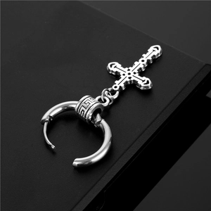 Detailed macro shot of a gothic stainless steel hoop earring with engraved cross pendant