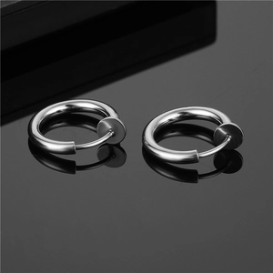 Macro view of silver clip-on hoop earrings with spring mechanism and smooth metal finish